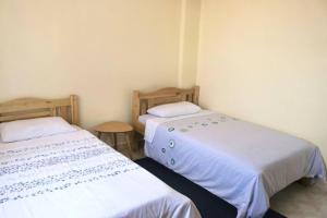 two beds sitting next to each other in a room at Cosy and spacious apartment in Meru in Meru