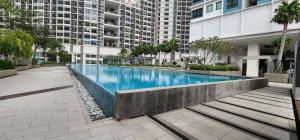 une grande piscine au milieu d'un bâtiment dans l'établissement Anggerik I Liberty I City Homestay, à Shah Alam