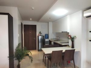 cocina y comedor con mesa y sillas en Tambuli Residence, en Maribago