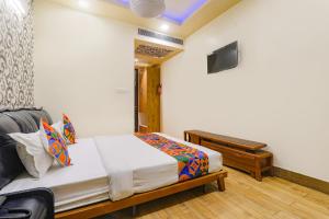 sypialnia z łóżkiem, telewizorem i pianinem w obiekcie FabHotel Shree Pushpraj w mieście Kanpur