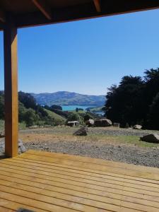 a wooden porch with a view of a beach at Glenwood Akaroa Bush Retreat - Totara Hut in Akaroa