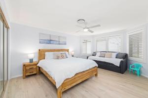 1 dormitorio con 1 cama y 1 sofá en Bagnall Beach Road 131, en Corlette