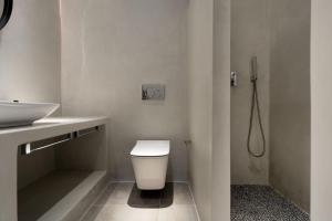 Łazienka z białą toaletą i umywalką w obiekcie Citrus Seaside Houses w mieście Plaka