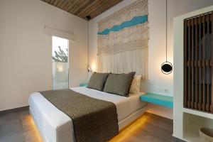 sypialnia z białym łóżkiem i oknem w obiekcie Citrus Seaside Houses w mieście Plaka +37 zdjęć