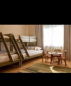 1 Schlafzimmer mit 2 Etagenbetten, einem Tisch und einem Fenster in der Unterkunft Petersen in Sibiu