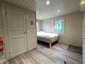a small bedroom with a bed and a window at Hietavilla Pläk in Ruka