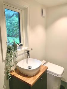 a bathroom with a white sink and a window at Tiny house - idyllic accommodation in Grimstad