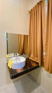 a bathroom with a sink and a mirror at DURIAN HILL VILLA in Gua Musang