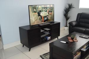 a living room with a black entertainment center with a television at Scenic Apartment in Windhoek City Centre in Windhoek