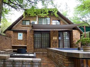 a brick house with a swimming pool in front of it at Weltevrede Lodge - Self Catering Houses in Marloth Park