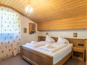 Apartment in Bad Kleinkirchheim ski resort في باد كلينكيرشهايم: غرفة نوم بسريرين وسقف خشبي