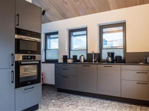 d'une cuisine avec des appareils en acier inoxydable et des fenêtres. dans l'établissement Chalet in Wald im Pinzgau near Krimml Falls, à Wald im Pinzgau