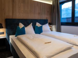 - une chambre avec 2 lits dotés d'oreillers bleus et blancs dans l'établissement Chalet in Wald im Pinzgau near Krimml Falls, à Wald im Pinzgau