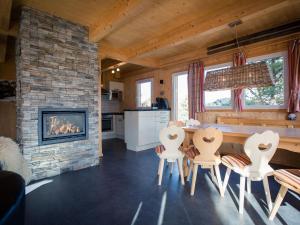 a living room with a fireplace and a table and chairs at Chalet Alpenpark Turracherhöhe 4 in Turracher Hohe