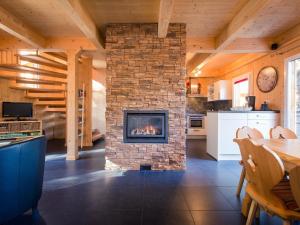 a fireplace in a room with a table and a kitchen at Chalet Alpenpark Turracherhöhe 4 in Turracher Hohe