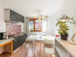 a kitchen with a sink and a table with chairs at Picturesque studio in Sibratsgf ll with garden in Sibratsgfäll