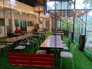 a restaurant with tables and chairs and windows at Rimtarn Hotel Pakchong in Pak Chong