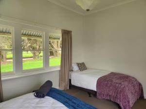RomseyにあるDeepfields Romsey Cottagesのベッドルーム1室(ベッド2台、窓2つ付)