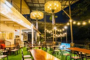 un restaurant avec des tables, des chaises et des lumières dans l'établissement Rimtarn Hotel Pakchong, à Pak Chong