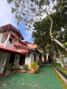 Ceylonima Home Stay في أنورادابورا: منزل أمامه حديقة خضراء