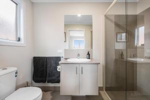 a bathroom with a toilet and a sink and a shower at John's Place San Remo Studio Couples Surfers Pets in San Remo