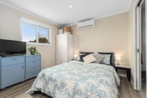 a bedroom with a bed and a flat screen tv at John's Place San Remo Studio Couples Surfers Pets in San Remo