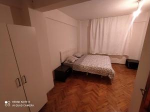 a small bedroom with a bed and a window at Uncular Flat 3+1 in Istanbul