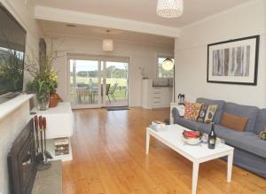 a living room with a couch and a table at Cosy 3 bedroom cottage with indoor fireplace in Romsey