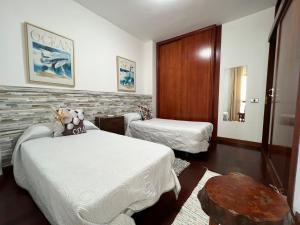 Habitación de hotel con 2 camas y mesa en LAS CANTERAS Sabor a Mar 2 Dormitorios "Parking Gratis", en Las Palmas de Gran Canaria