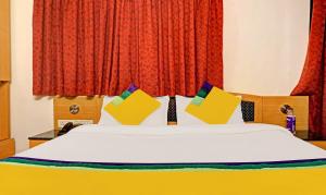 a bedroom with a bed with colorful pillows on it at Itsy By Treebo - Crown Inn in Pune