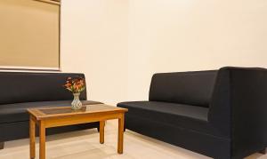 a living room with a couch and a coffee table at Itsy By Treebo - Crown Inn in Pune