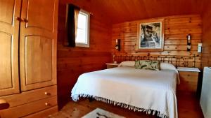 1 dormitorio con 1 cama en una cabaña de madera en Casitas La Purísima Lavanda, en Requena