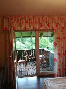 a room with a balcony with a table and chairs at Apartment Christopherhof 56 Grafenwiesen in Grafenwiesen