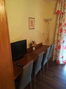 a room with a table with chairs and a television at Apartment Christopherhof 56 Grafenwiesen in Grafenwiesen