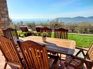 Une table et des chaises en bois sont disponibles sur la terrasse. dans l'établissement A CASA DI OLIVO, à Castelnuovo Magra