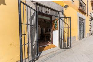 an open door of a yellow building with an open window at Encantador apartamento en Calle Segovia in Madrid