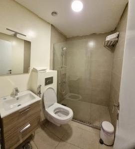 a bathroom with a toilet and a shower and a sink at Byblos Prime in Aqaba