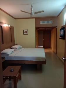 a bedroom with a large bed and a table at Hotel A P in Coimbatore