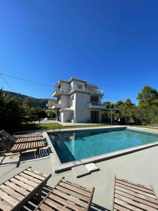 a villa with a swimming pool in front of a house at Lefkada Beach Villa in Lefkada Town