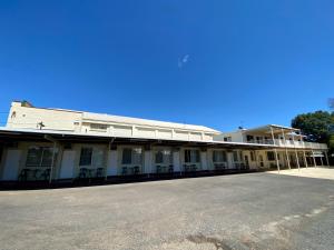 an old building with chairs in front of it at Golden Grain Motel in Pittsworth