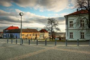 una calle con edificios y un reloj en un poste en Cozy friendly place with free parking en Praga