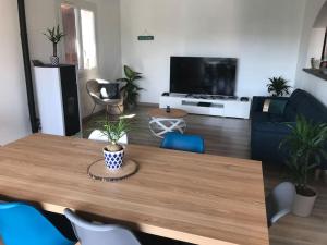 salon z drewnianym stołem z krzesłami i telewizorem w obiekcie Villa Cléa, belle propriété provençale, jardin, piscine, au calme w mieście Carnoux-en-Provence
