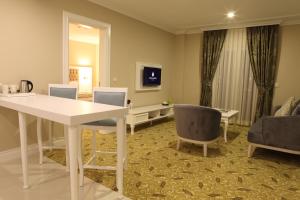 sala de estar con mesa blanca y sillas en Luxor Garden Hotel, en Kocaeli