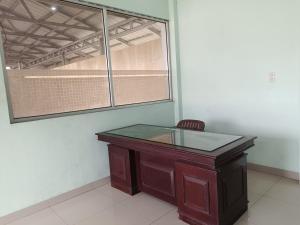 a wooden desk in a room with a window at OYO 91874 Kisaran Residence Syariah in Kisaran