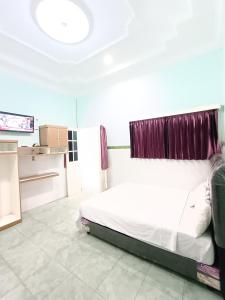 a bedroom with a bed and a kitchen at OYO 91874 Kisaran Residence Syariah in Kisaran