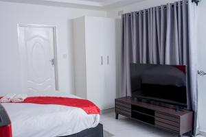 a bedroom with a bed and a flat screen tv at Mt Pleasant Bed and Breakfast Ltd in Harare