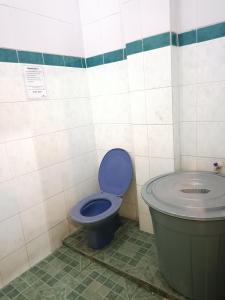 a bathroom with a blue toilet and a sink at OYO 91874 Kisaran Residence Syariah in Kisaran