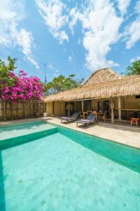 een villa met een zwembad en een rieten dak bij Villa Matahari - Cute 1 bdr villa with private pool in Gili Meno
