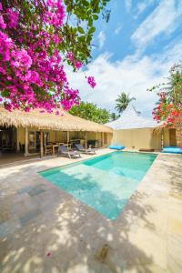 een villa met een zwembad en bloemen bij Villa Matahari - Cute 1 bdr villa with private pool in Gili Meno