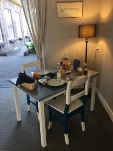 een tafel met twee stoelen en een tafel met eten erop bij Guesthouse Thoez in Maastricht